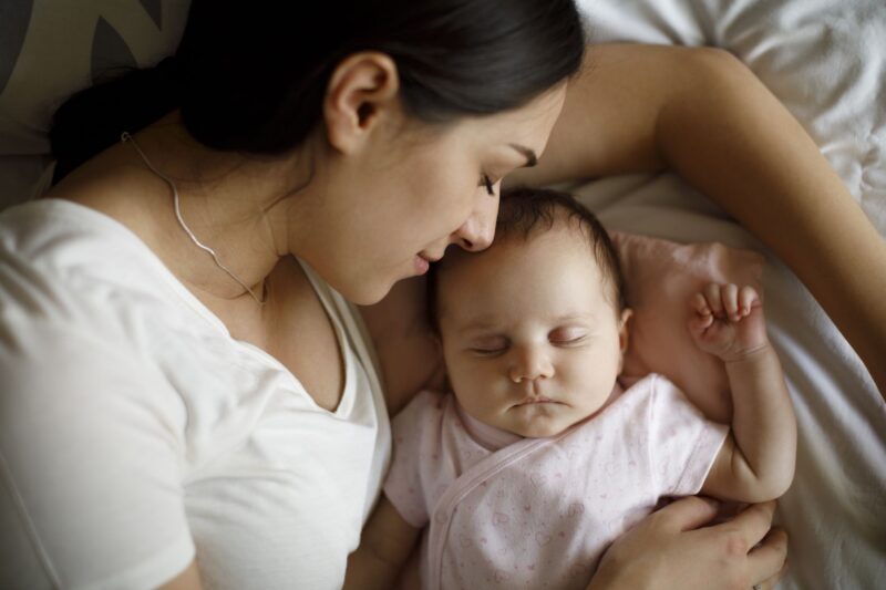 Bild einer Mutter, die das Baby in ihren Armen in den Schlaf wiegt